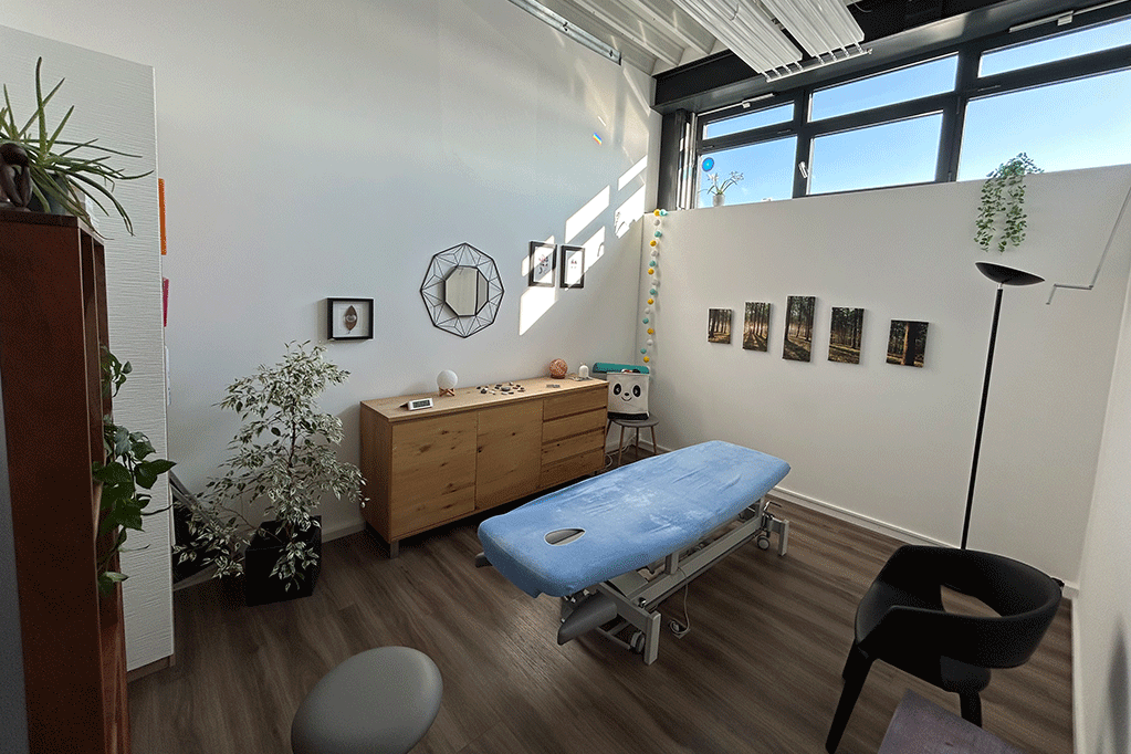 Un lit de massage bleue dans une grande pièce relaxante.