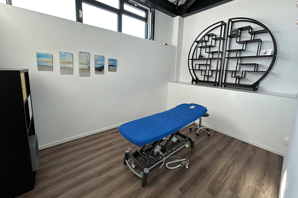 Un lit de massage bleue dans une pièce blanche.